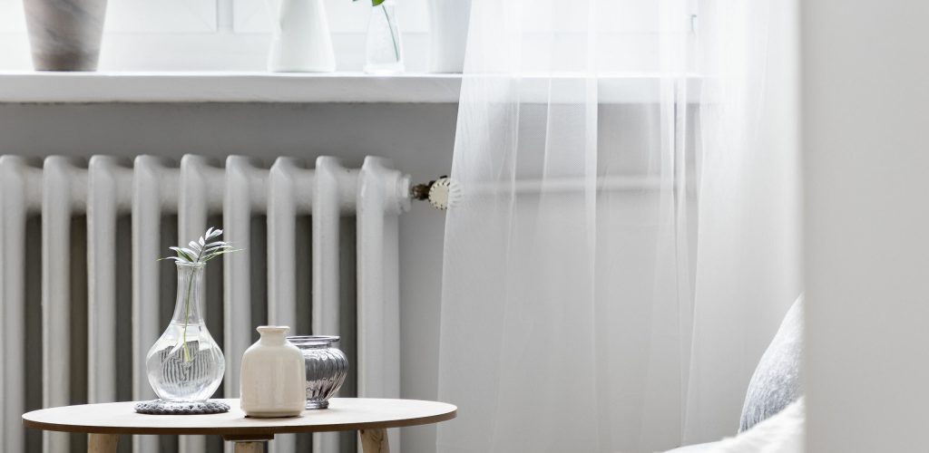 Stylish home interior with small table standing beside window